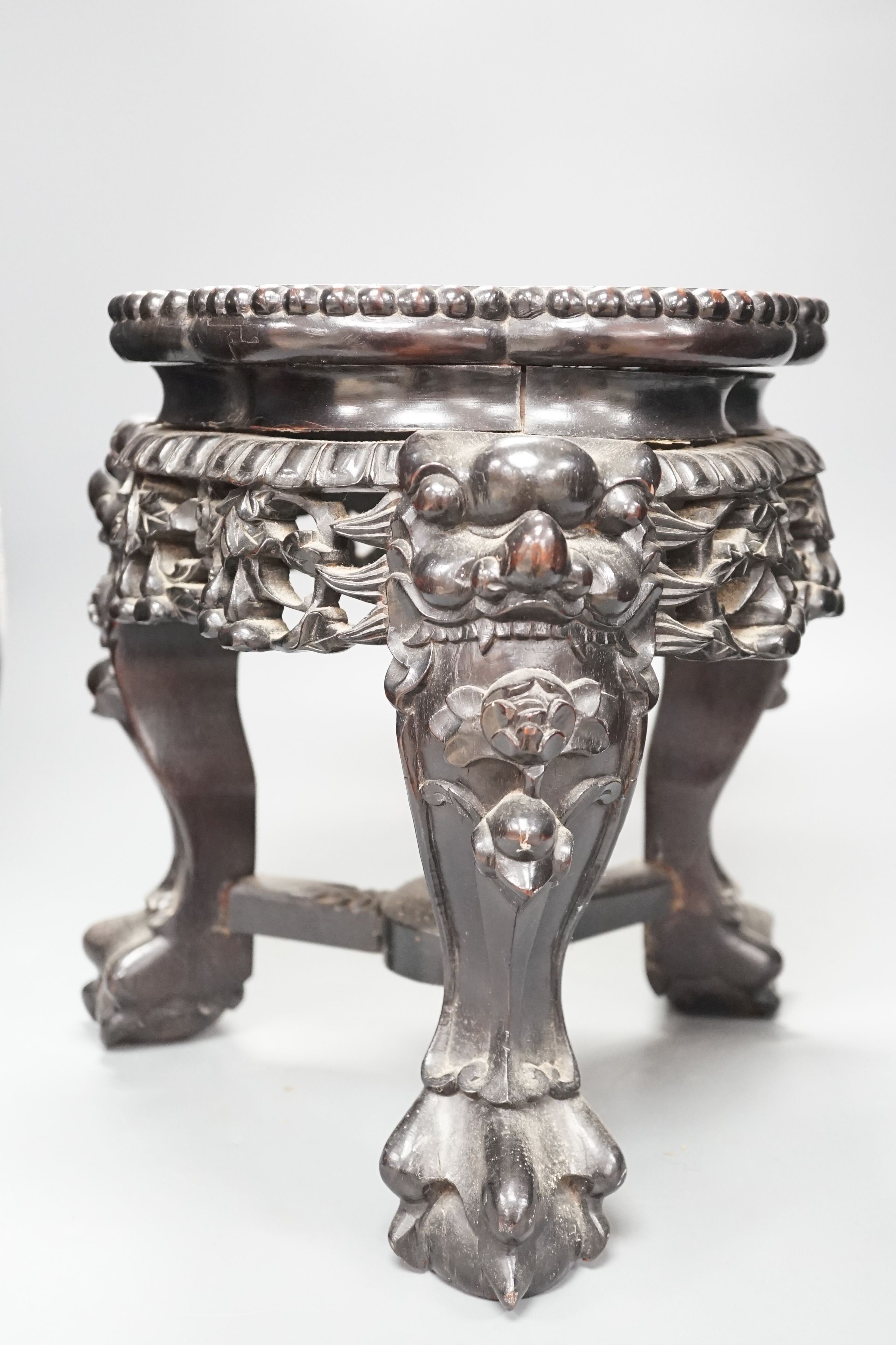 AChinese carved wood jardiniere stand, late Qing dynasty, with hard stone inset, top 26 cms diameter.